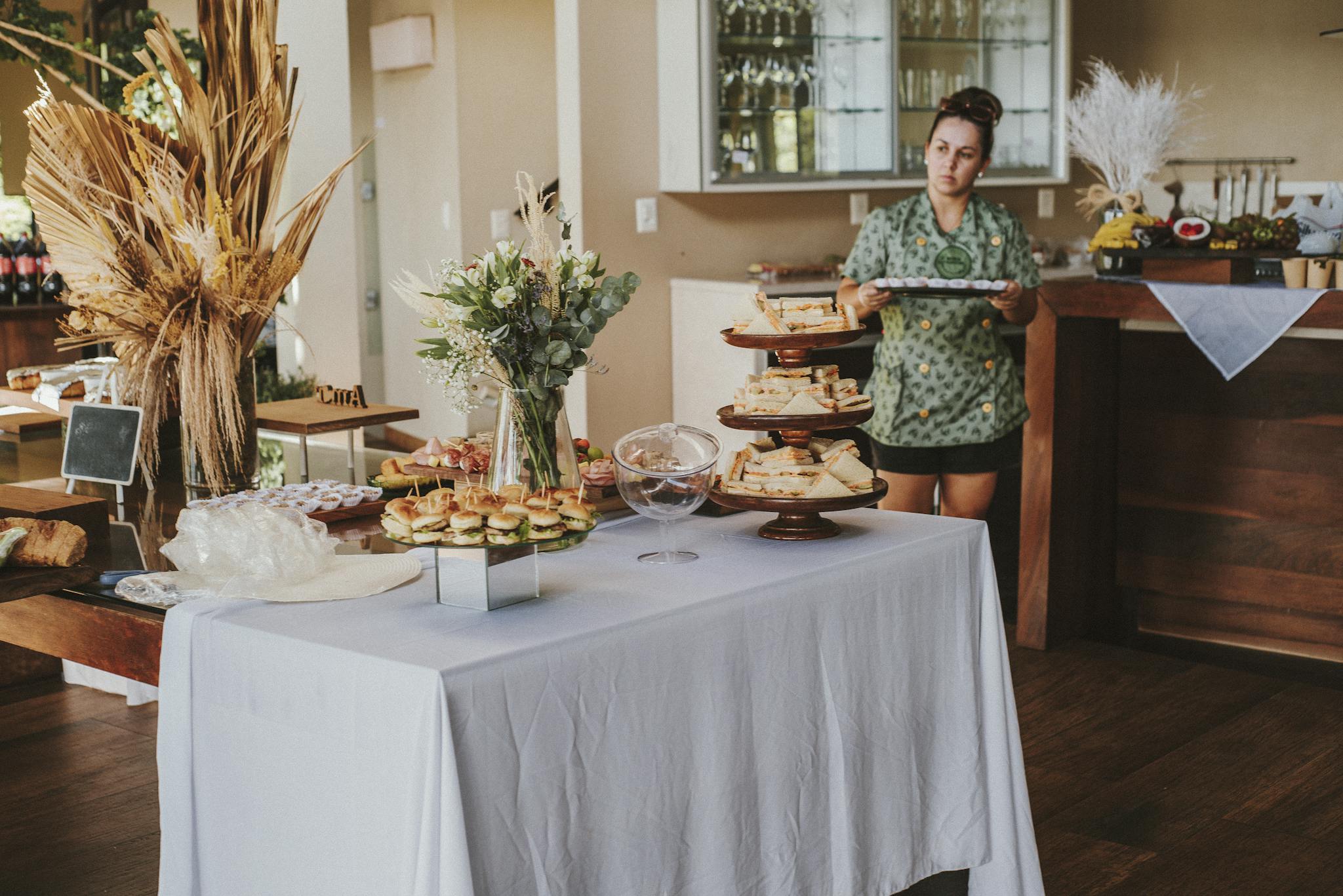 Beautiful buffet setup with floral arrangements and snacks indoors at Garopaba, Brazil.