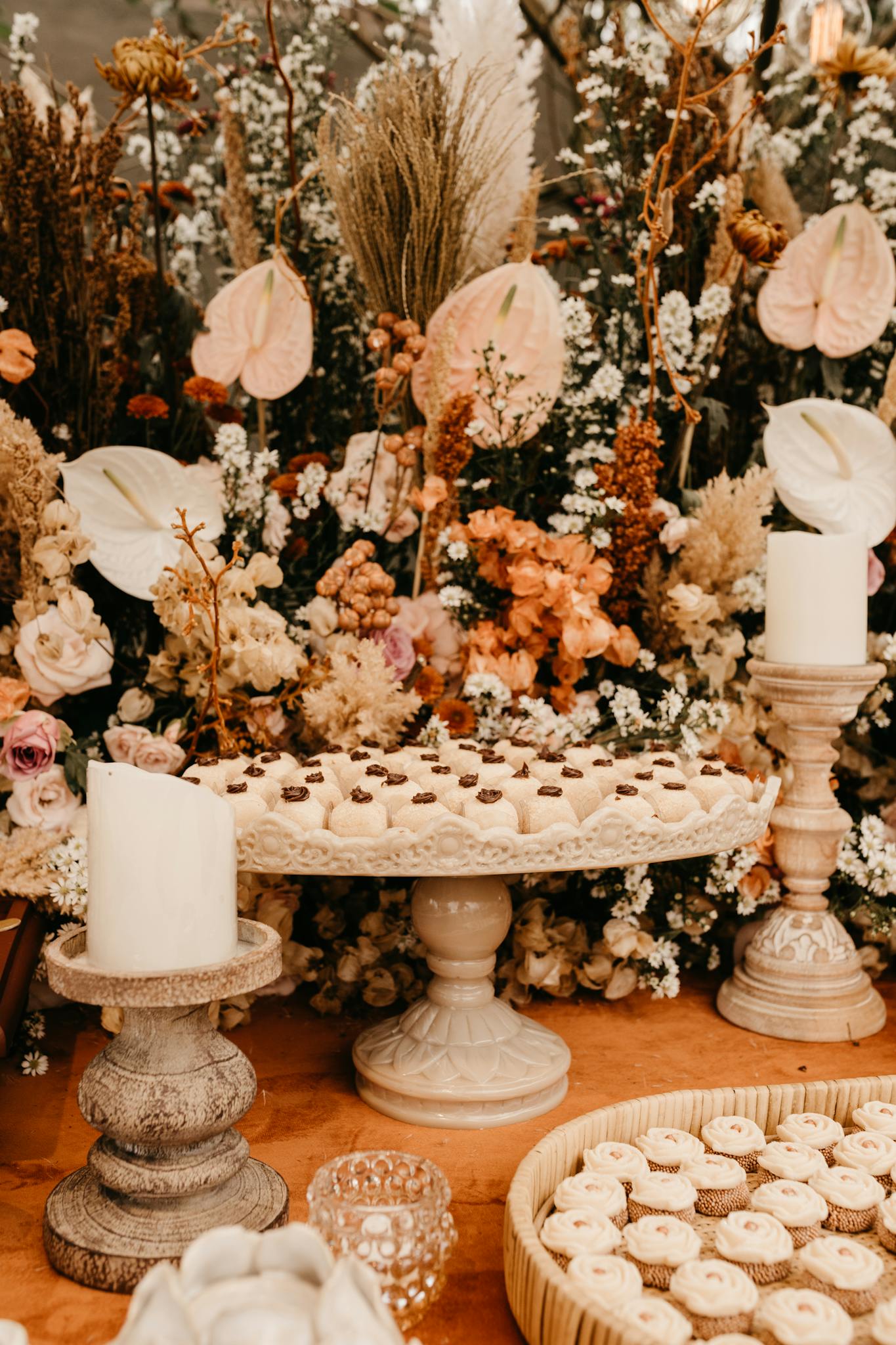 Beautifully decorated dessert table with florals and elegant candleholders, perfect for events.