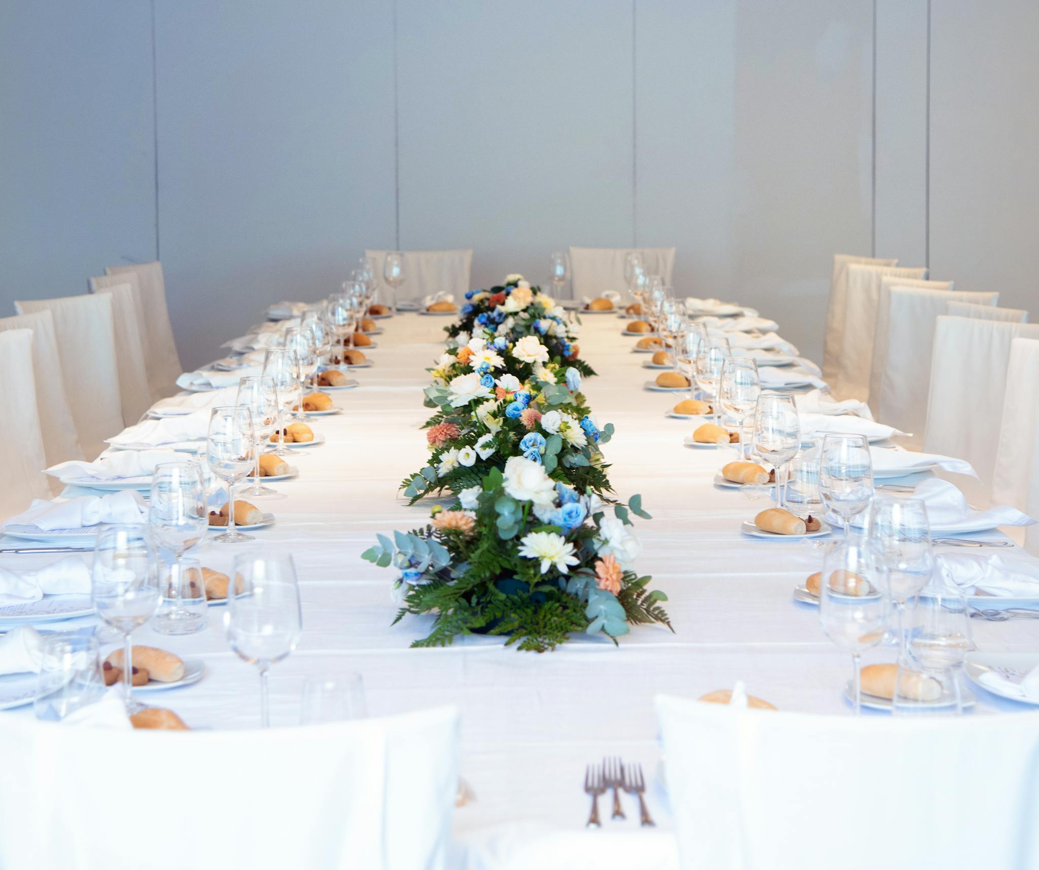 Luxurious banquet table setting with a vibrant floral centerpiece, ready for an elegant indoor event.